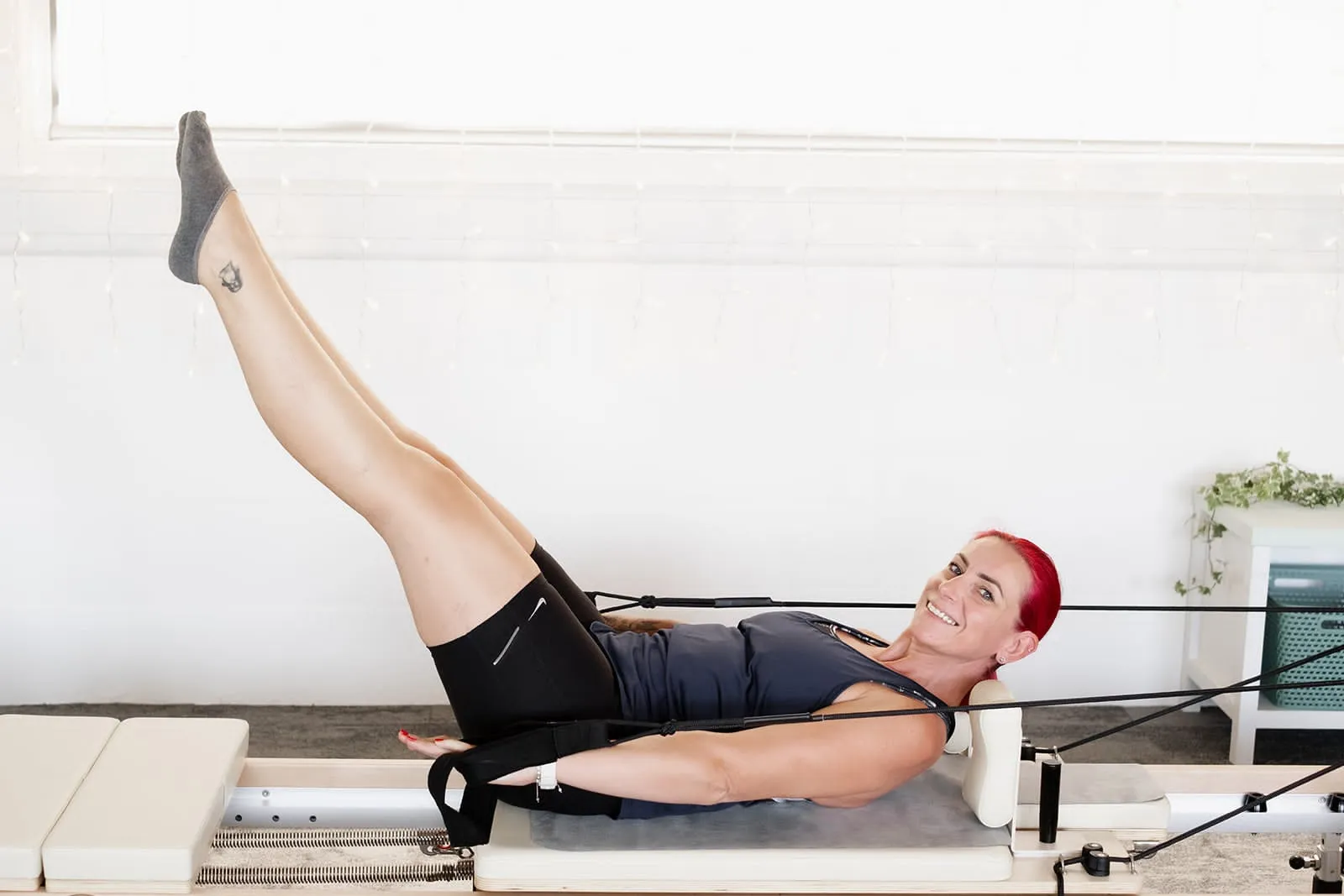 Legs in straps on the reformer during a Reformer Foundations class