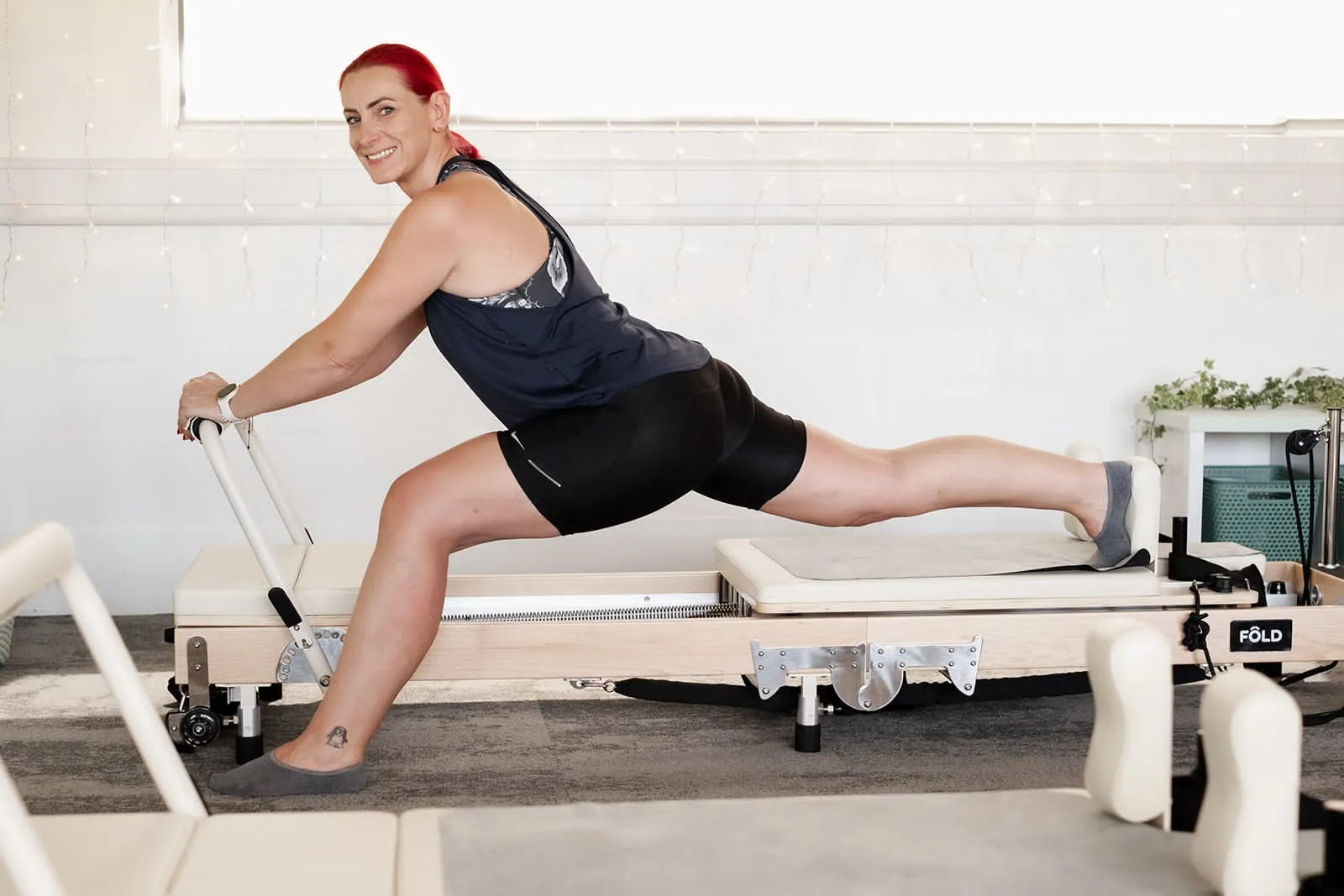 Client in a deep lunge on the reformer at Pilates Flow Reformer, Gloucester