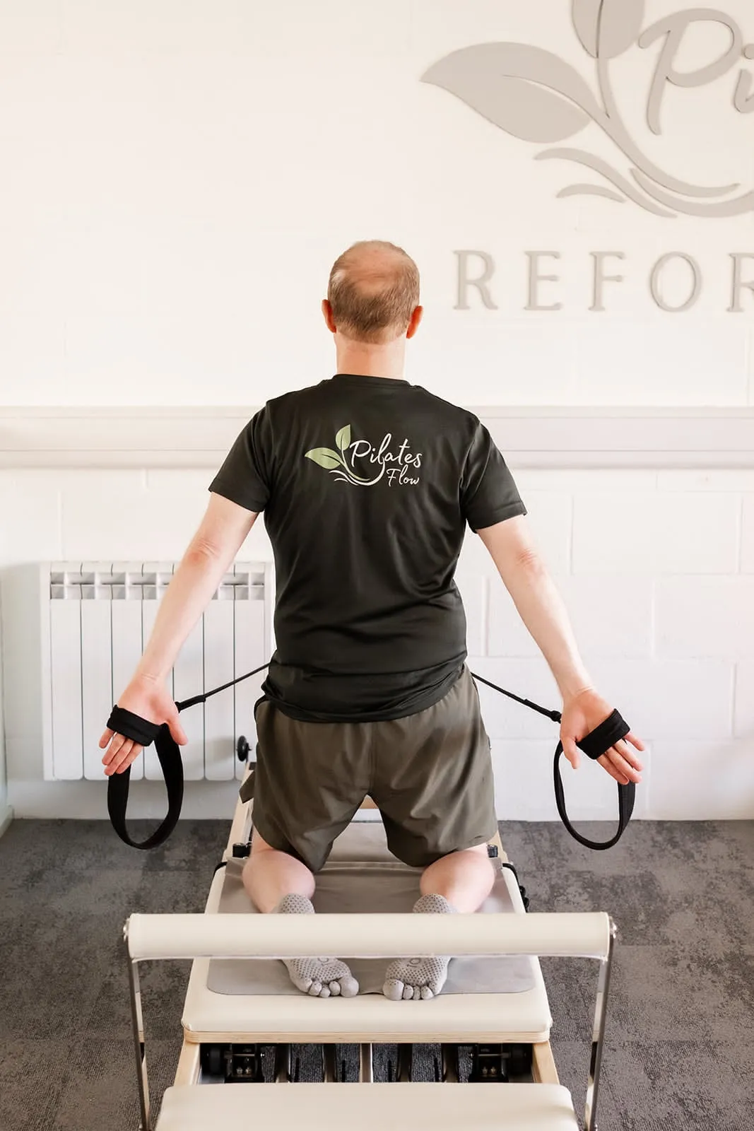 Kneeling reformer exercise with straps at Pilates Flow Reformer